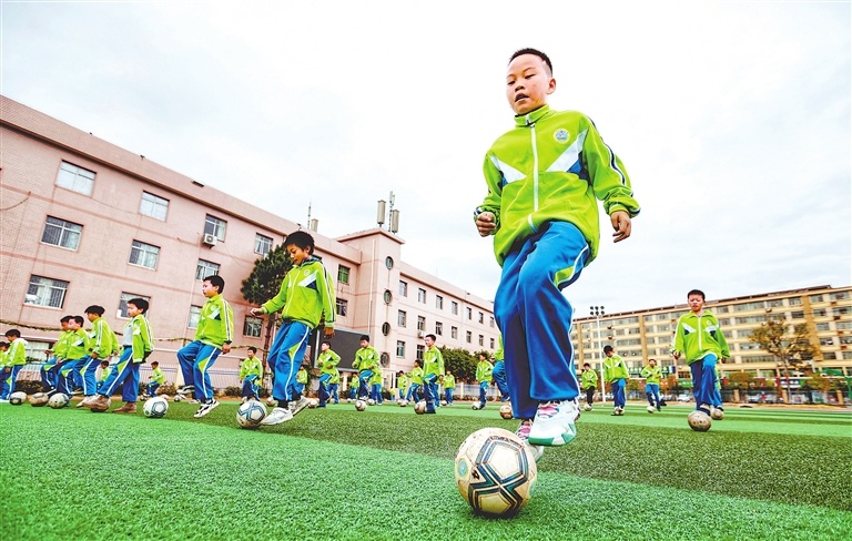 在广昌县第三小学操场上，校园足球队的队员们在进行盘带和控球训练。江西日报全媒体记者 徐 铮摄