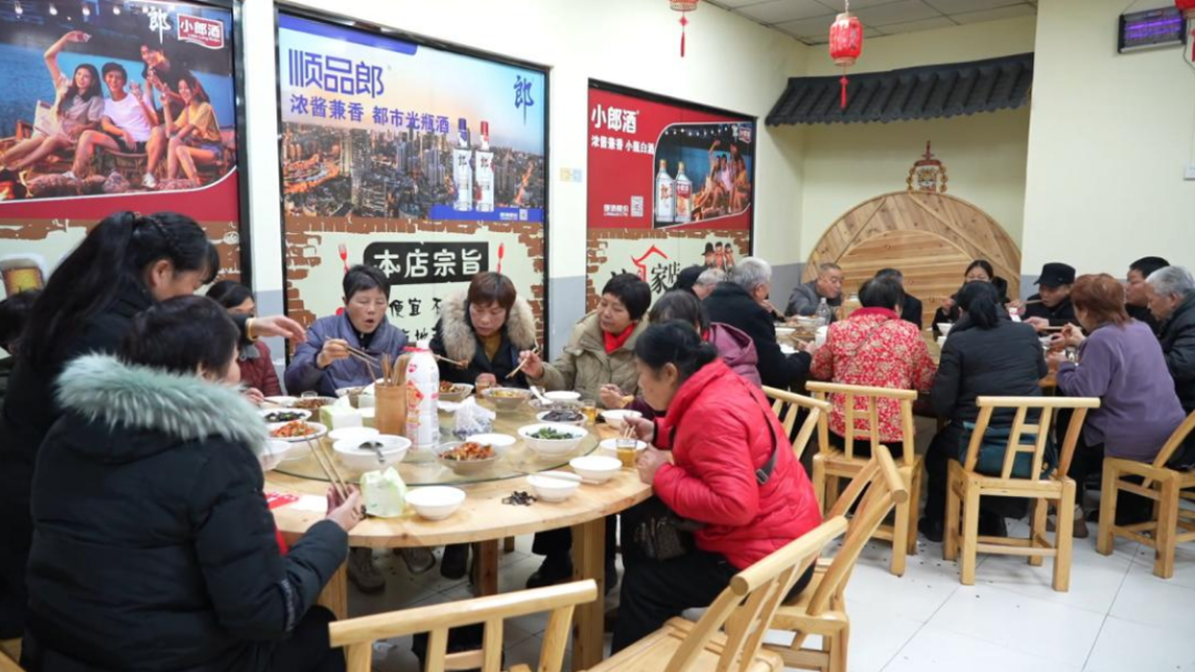 万载“齐家吃饭”城市老年人助餐服务点，老年朋友正聚在一起在吃午饭。